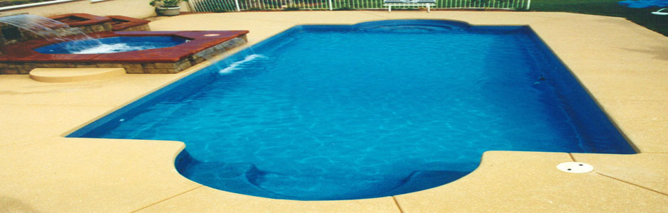 Blue swimming pool with a raised spa on a paved terrace