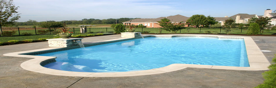 Swimming pool beside a lawn and paved terrace
